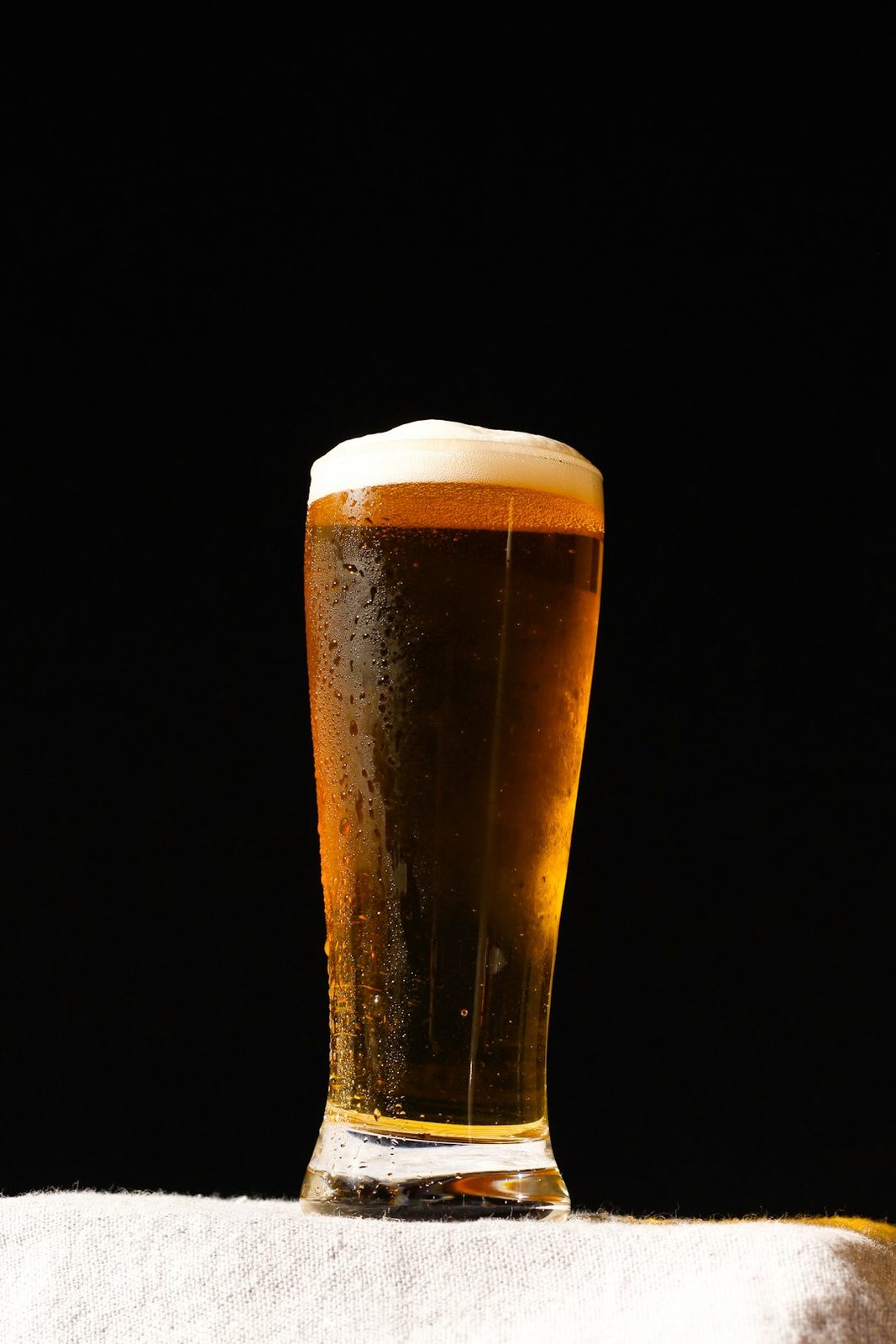 Una copa de cerveza siendo servida, una bebida alcohólica que puede reducir el flujo de sangre al oído interno